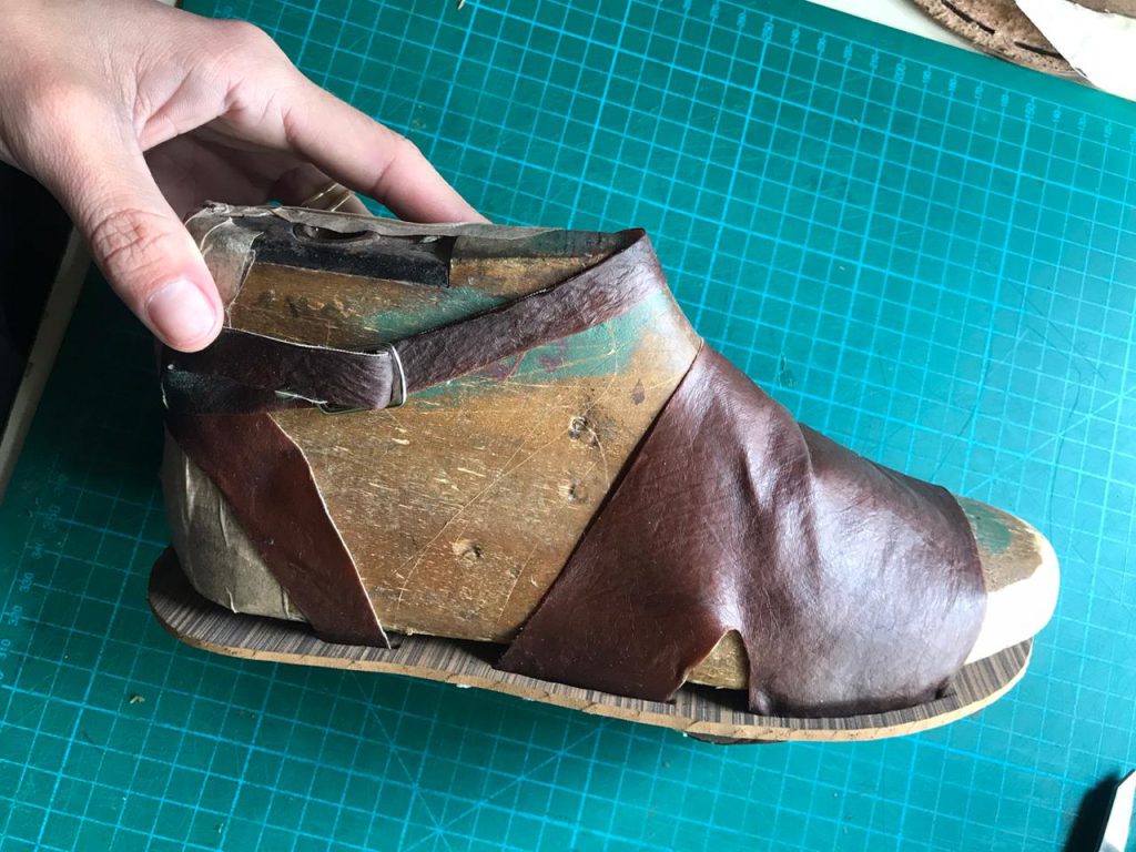 Confecção artesanal do sapato, ainda sendo testado com o molde.